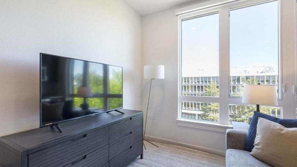 een woonkamer met een flatscreen-tv op een dressoir bij Landing Modern Apartment with Amazing Amenities (ID5061X74) in Portland