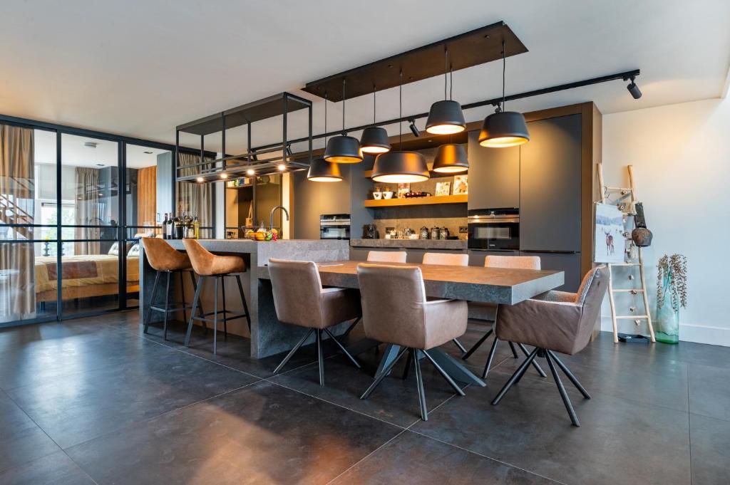 an open kitchen with a wooden table and chairs at Het-Boothuys in Harderwijk