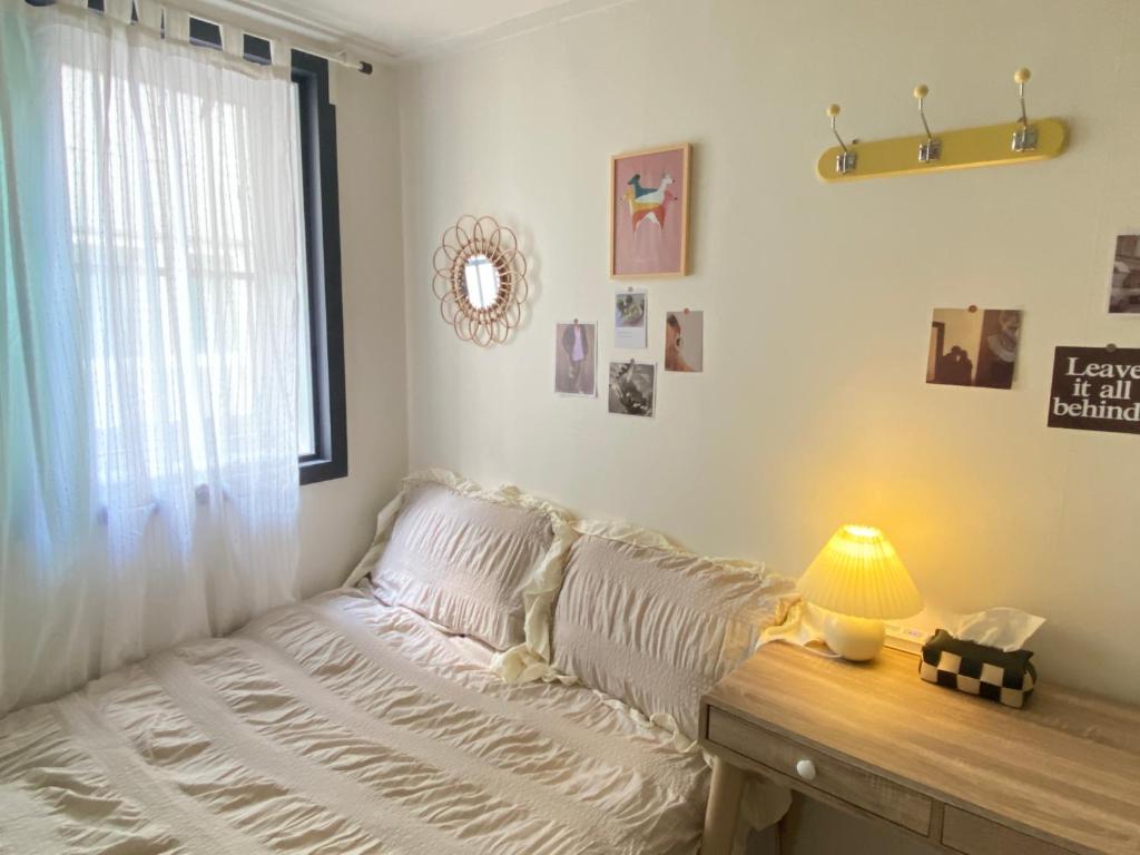 a bed in a room with a window and a lamp at Morning room RED PANDA GUESTHOUSE in Seoul