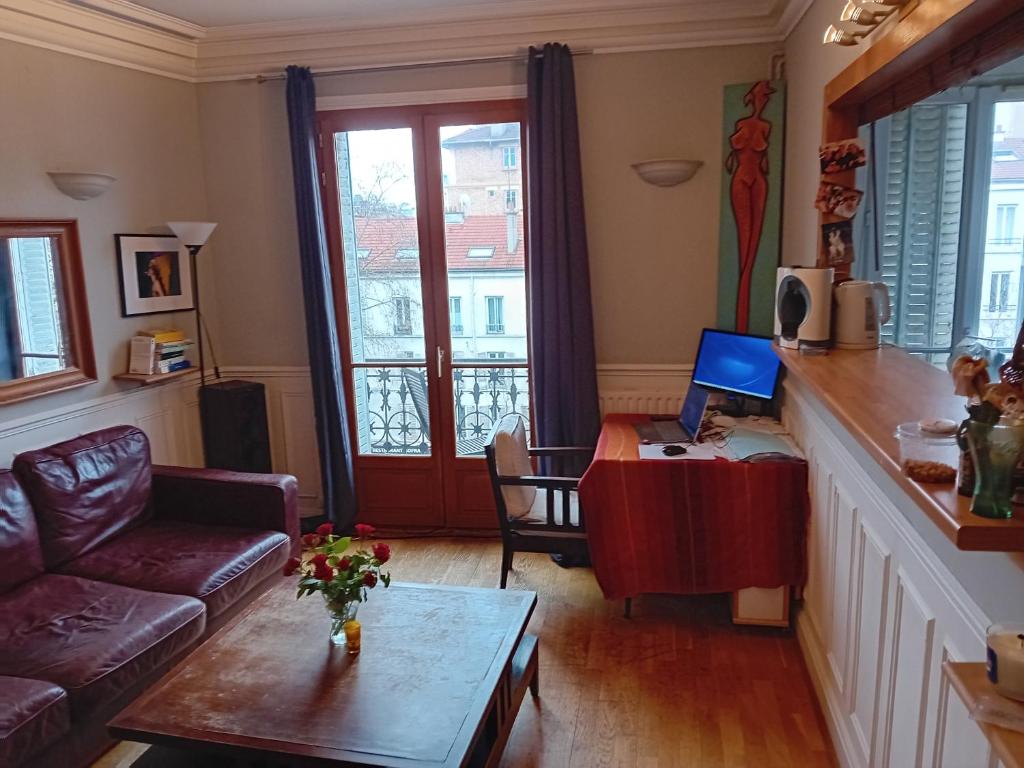 un salon avec un canapé et une table dans l'établissement Appartement 50 m2 Centre Boulogne Metro en bas, tous commerces, à Boulogne-Billancourt