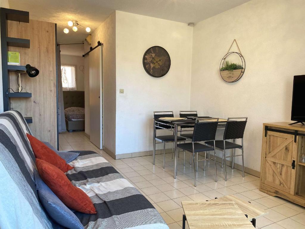 un salon avec une table, des chaises et une télévision dans l'établissement Appartement T1 avec terrasse, tout équipé, proche commodités à Balaruc-les-Bains - FR-1-553-239, à Balaruc-les-Bains