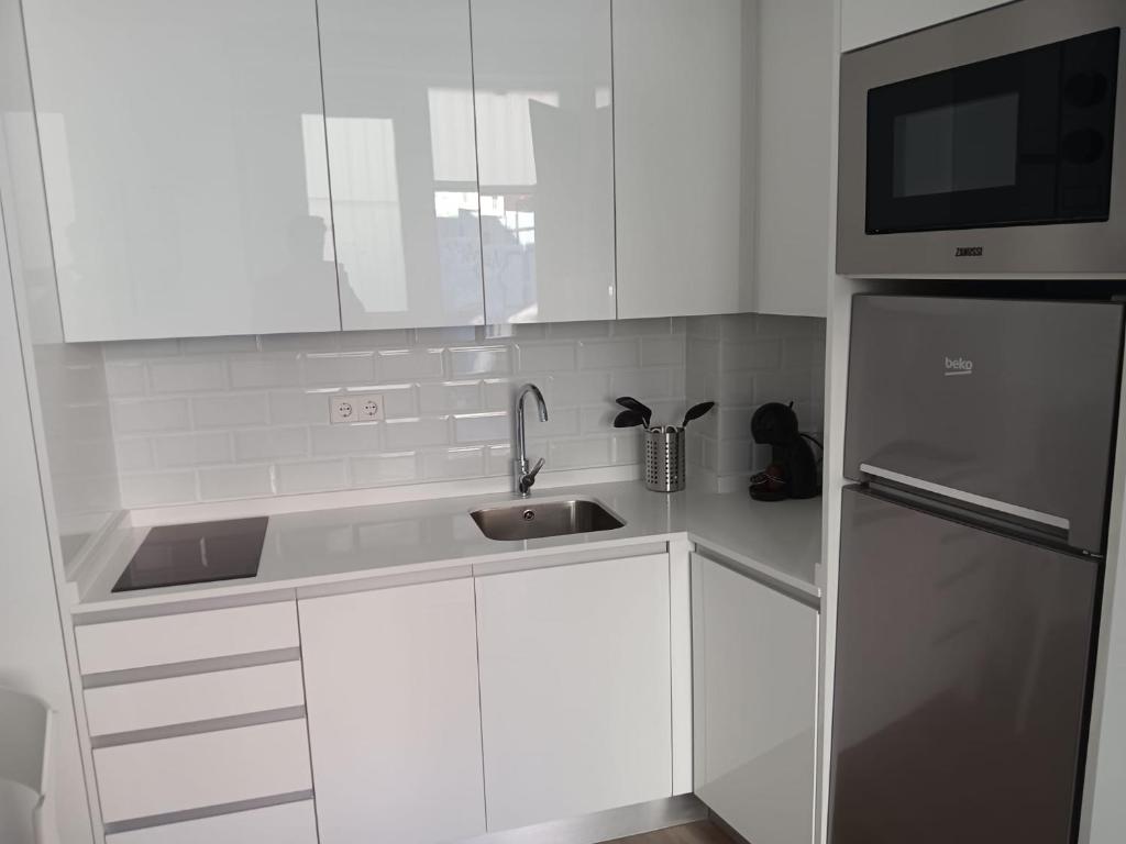 a white kitchen with a sink and a refrigerator at Francos Rodriguez1 Apartments in Madrid