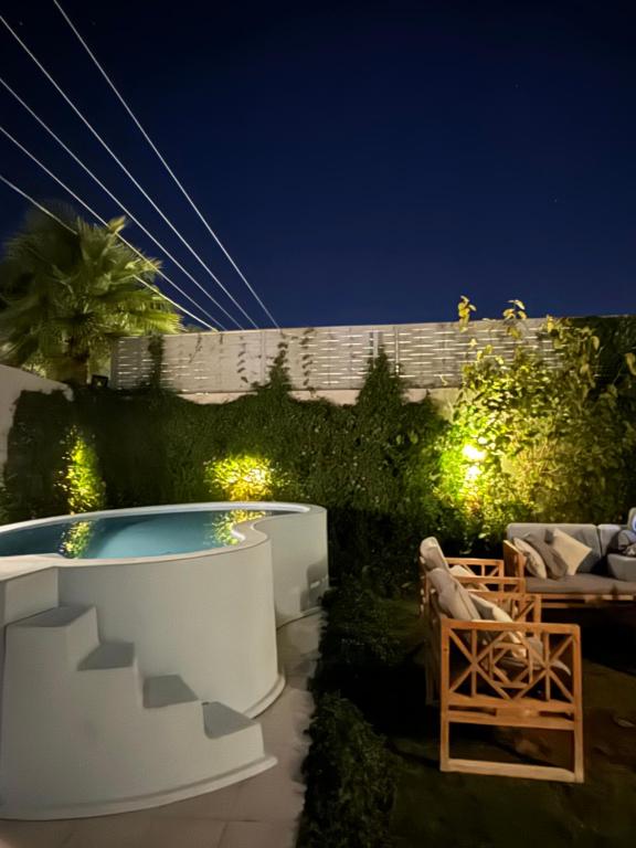un patio trasero con piscina por la noche en شاليه الماسيه خاص و مميز بأحدث المواصفات لنصنع الجمال بعينه, en Riad