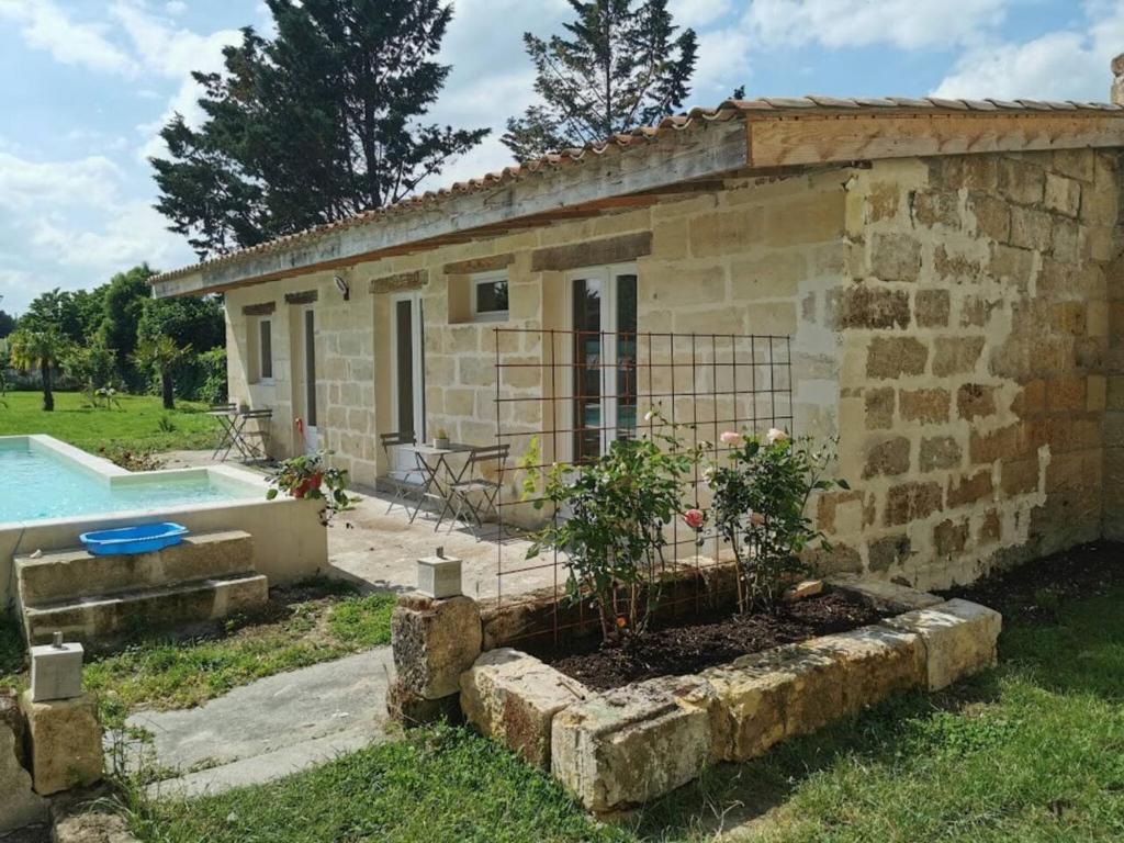 Cette petite maison en pierre dispose d'un jardin et d'une piscine. dans l'établissement Maison d'une chambre avec piscine partagee terrasse et wifi a Sainte Terre, à Sainte-Terre