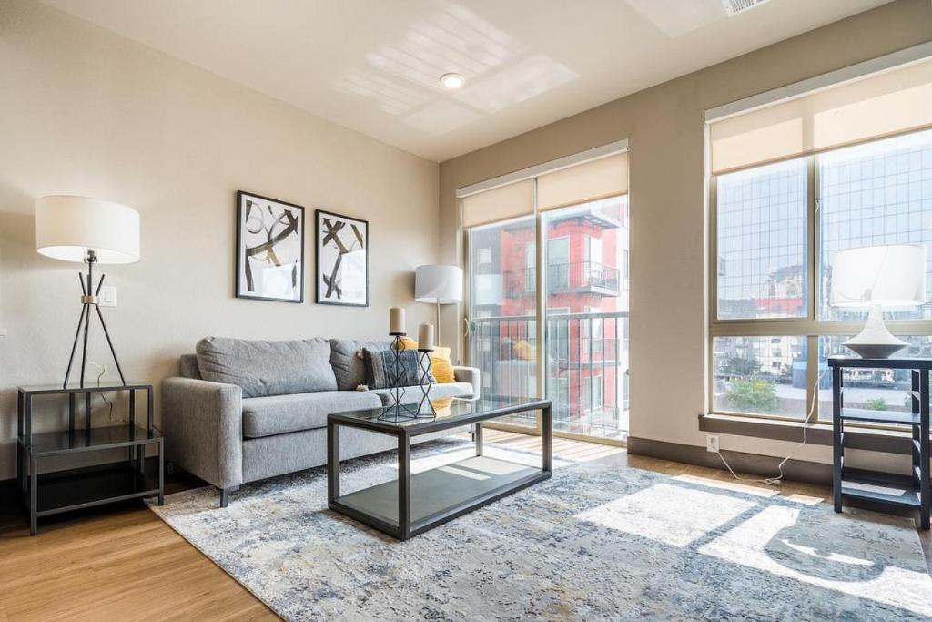 uma sala de estar com um sofá e uma mesa em Landing Modern Apartment with Amazing Amenities (ID1959) em Denver