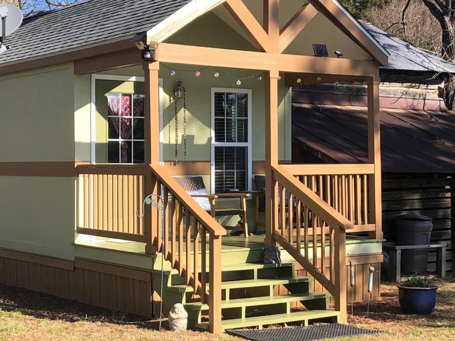 een klein huis met een veranda en een terras bij Cozy and Peaceful Tiny House on a 100-acre Farm in Lewisville