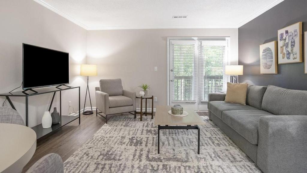 uma sala de estar com um sofá e uma televisão em Landing Modern Apartment with Amazing Amenities (ID1204X607) em Charlotte