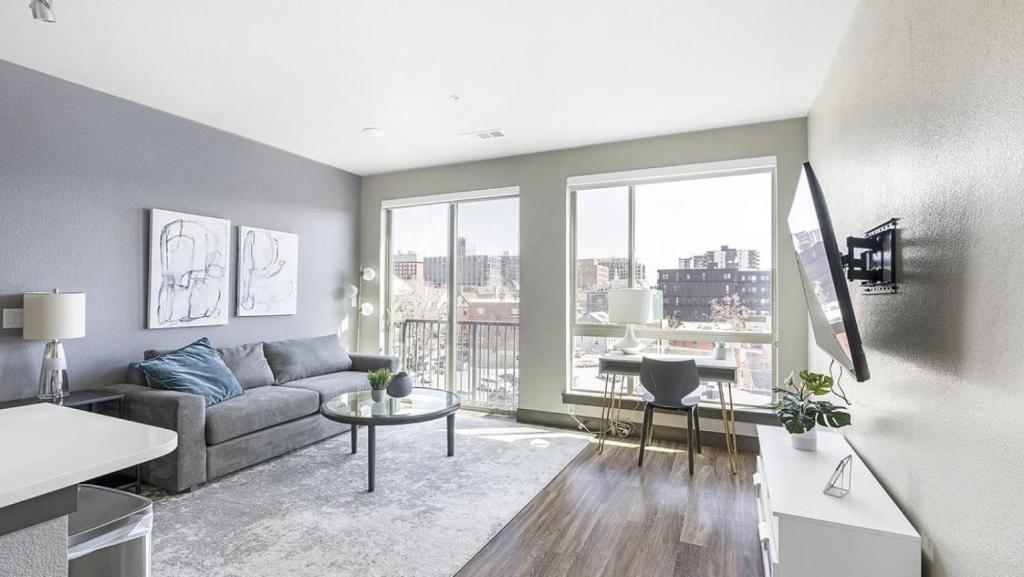 uma sala de estar com um sofá e uma grande janela em Landing Modern Apartment with Amazing Amenities (ID1960) em Denver