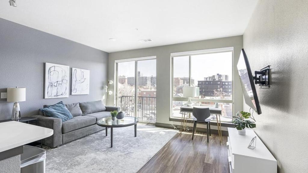 a living room with a couch and a large window at Landing Modern Apartment with Amazing Amenities (ID1960) in Denver