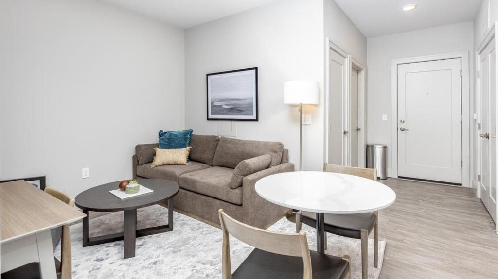 ein Wohnzimmer mit einem Sofa und einem Tisch in der Unterkunft Landing Modern Apartment with Amazing Amenities (ID6308X34) in Columbus