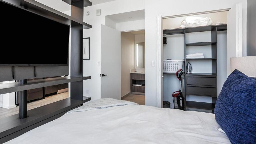 Landing Modern Apartment with Amazing Amenities (ID870) في فورت لاودردال: غرفة نوم بسرير وتلفزيون كبير
