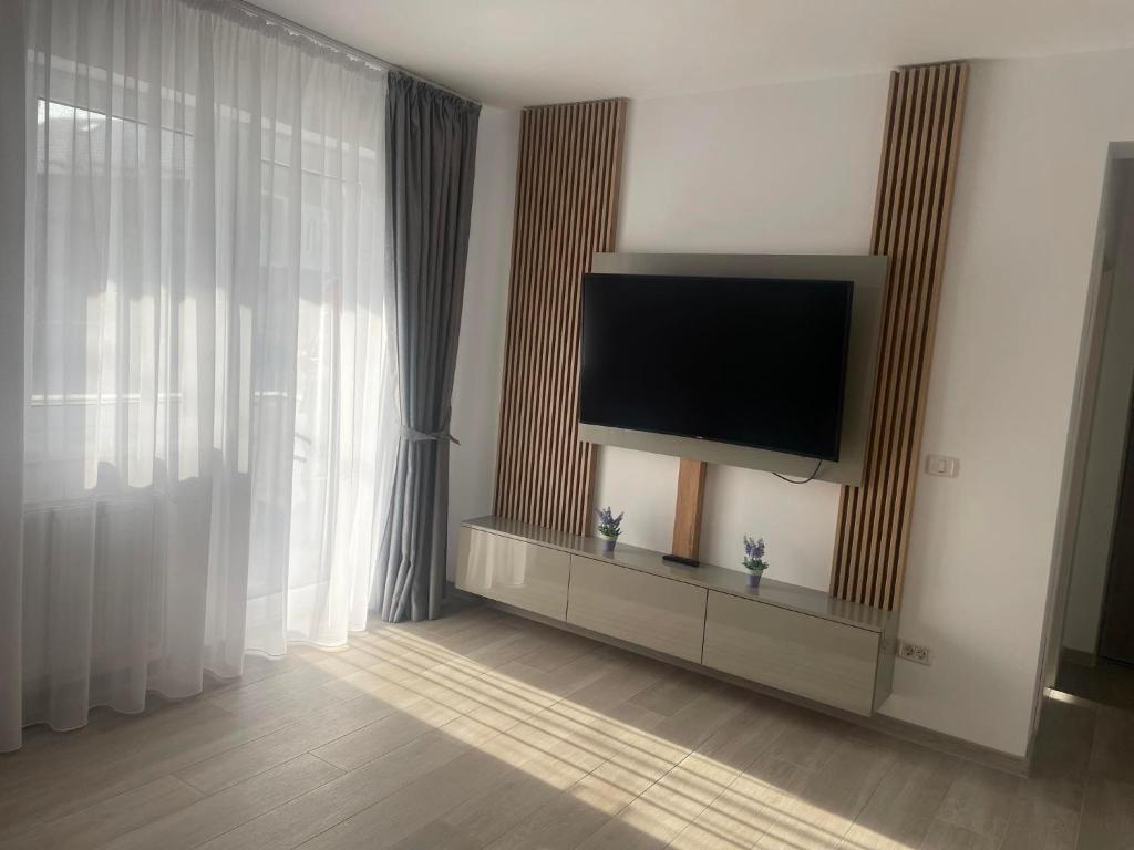 a living room with a flat screen tv on a wall at Luxury Apartment in Piteşti