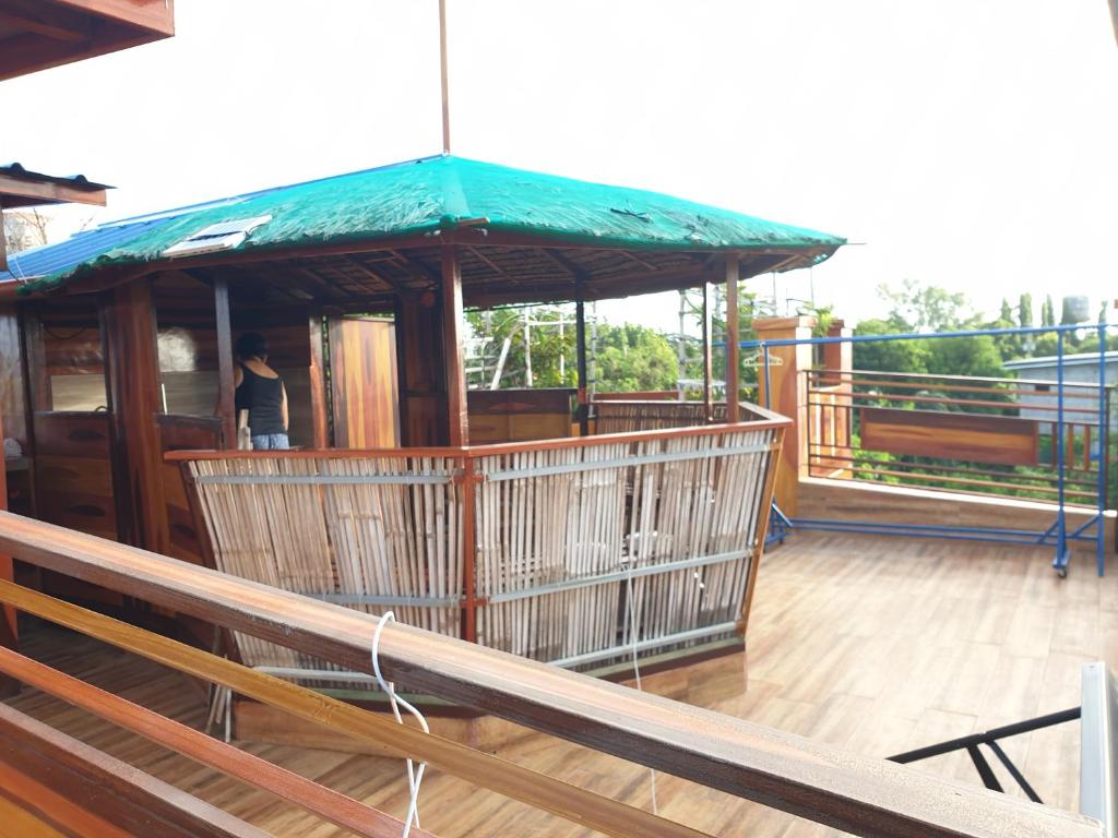 Cabuyao的住宿－Casa de madera the wooden house，一座在甲板上设有绿色屋顶的建筑