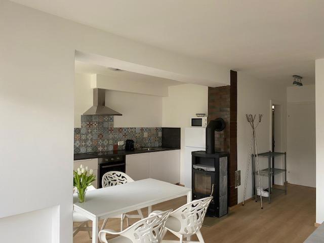 uma cozinha branca com uma mesa e cadeiras brancas em Ferienwohnung Seeluft em Keutschach am See