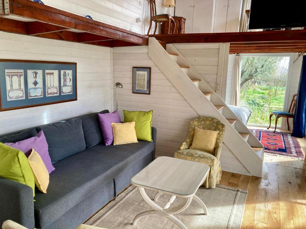 a living room with a couch and stairs at Lakeside Hideaway Cabin in Bursa