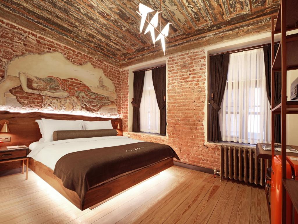 Impera Hotel - Special Category في إسطنبول: غرفة نوم بسرير كبير في جدار من الطوب