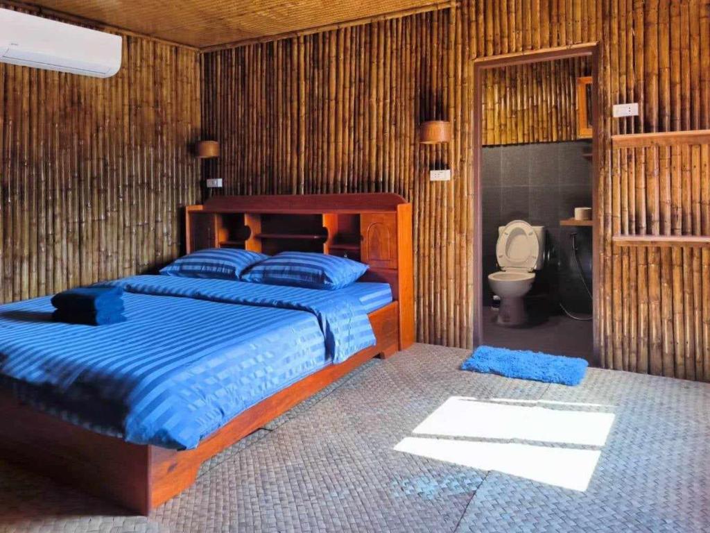 een slaapkamer met een bed en een badkamer met een toilet bij Nana Bungalows in Ban Tan