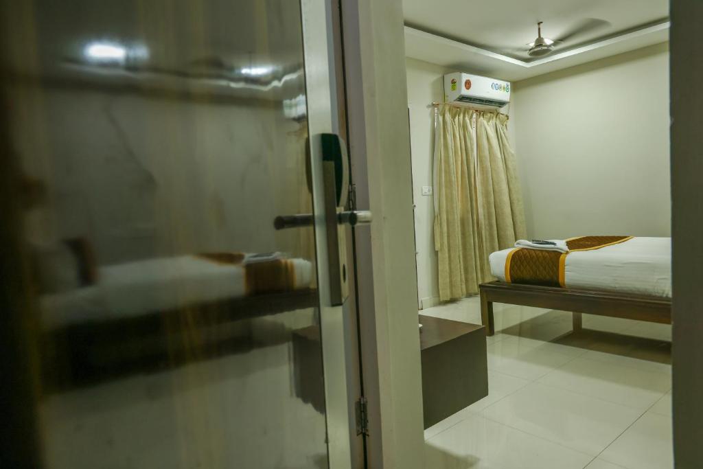 a view of a bedroom with a bed and a window at Rithikha Inn Crest in Chennai