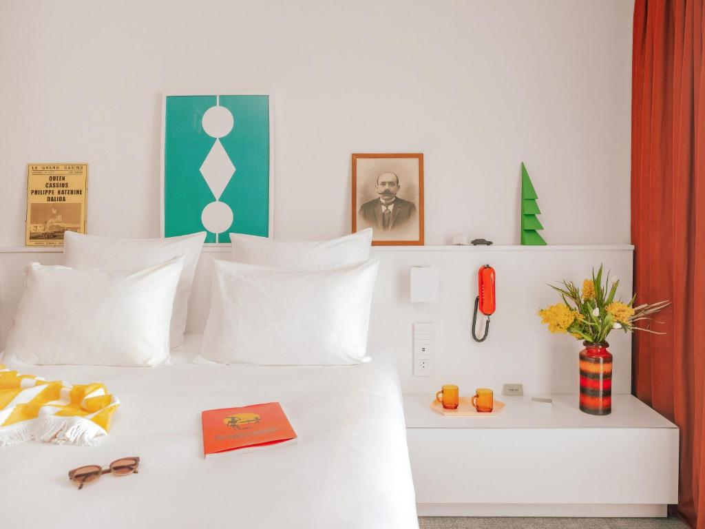 sypialnia z białym łóżkiem i białymi poduszkami w obiekcie Vertime Les Sables w mieście Les Sables-dʼOlonne