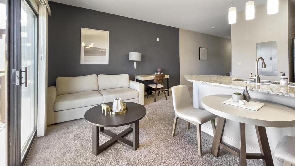 a kitchen and living room with a couch and a table at Landing Modern Apartment with Amazing Amenities (ID1228X214) in Greenville