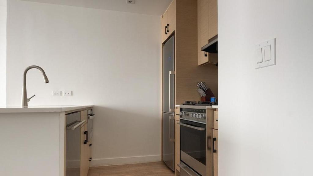 cocina con fregadero y fogones en Landing Modern Apartment with Amazing Amenities (ID3117X83) en Nueva York