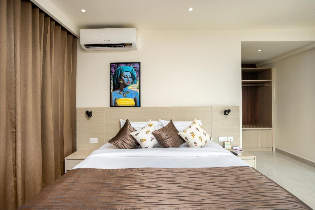a bedroom with a large bed with brown pillows at PRESIDENCY AIRPORT HOTEL in Cochin