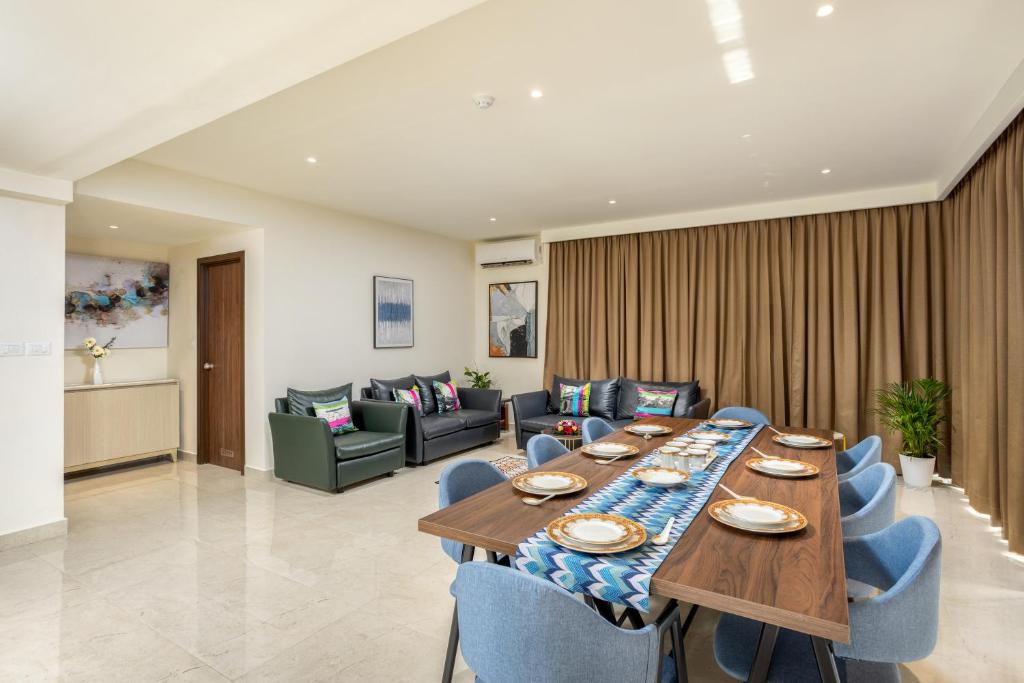 a dining room with a long table and blue chairs at PRESIDENCY AIRPORT HOTEL in Cochin