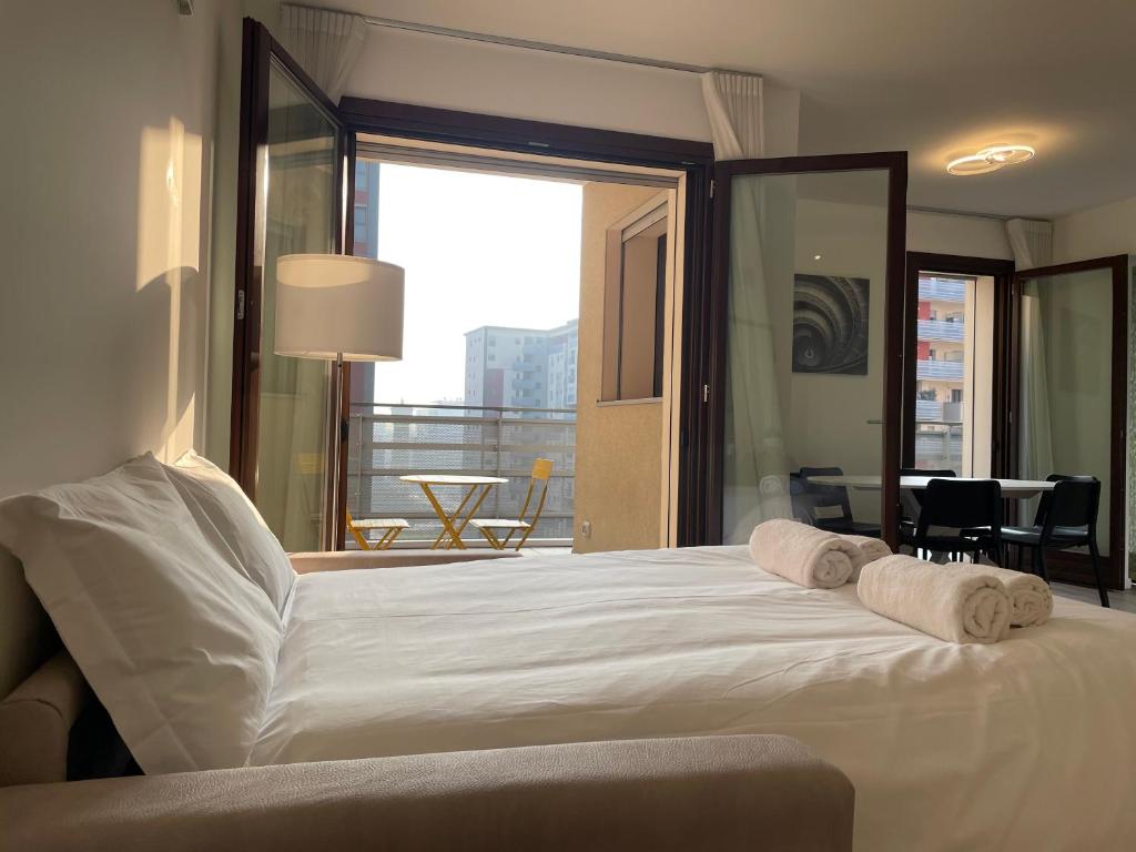 a bedroom with a large white bed with towels on it at Hospitami Apartment - 15 min Duomo Milano in Milan