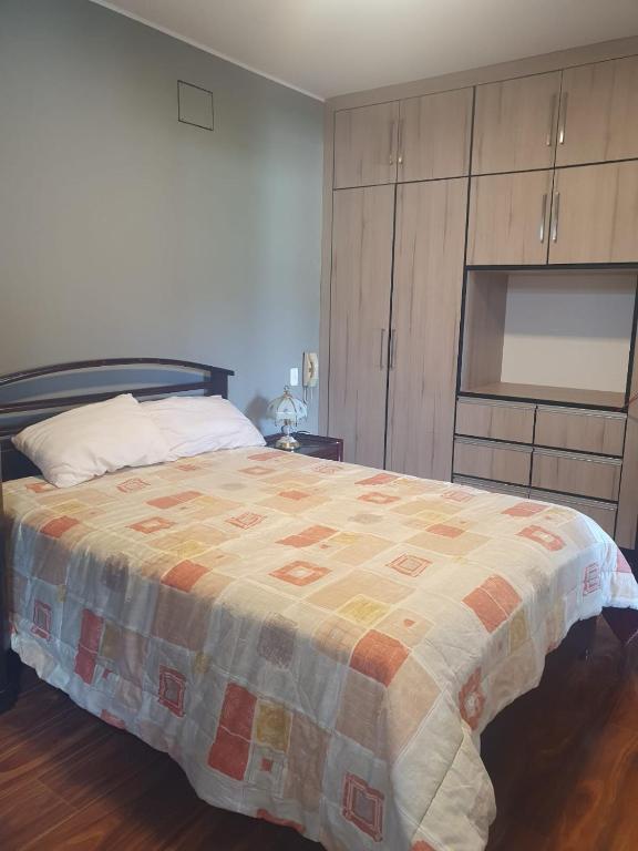 a bedroom with a bed with a quilt on it at Adelita Departamento in Loja