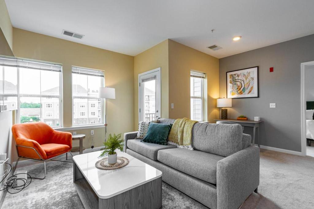 ein Wohnzimmer mit einem Sofa und einem Tisch in der Unterkunft Landing Modern Apartment with Amazing Amenities (ID2286) in Ellicott City