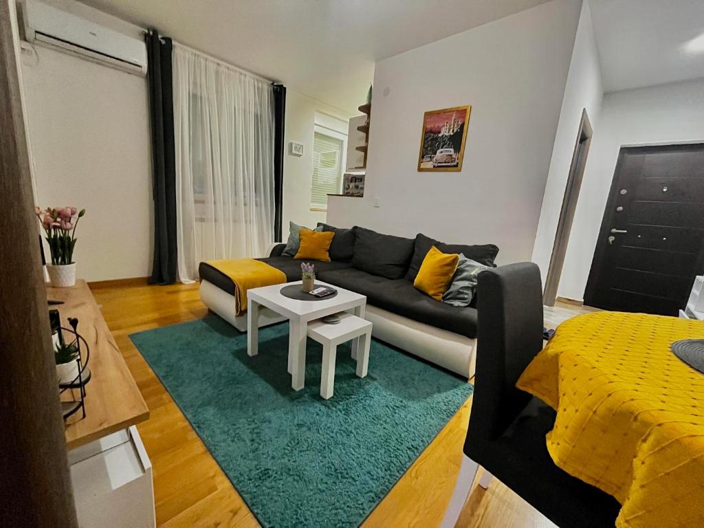 uma sala de estar com um sofá e uma mesa em Yellow em Belgrado