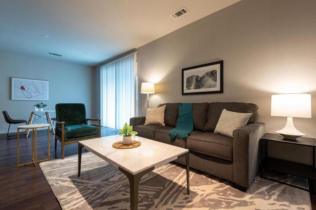 uma sala de estar com um sofá e uma mesa em Landing Modern Apartment with Amazing Amenities (ID2977X82) em Austin