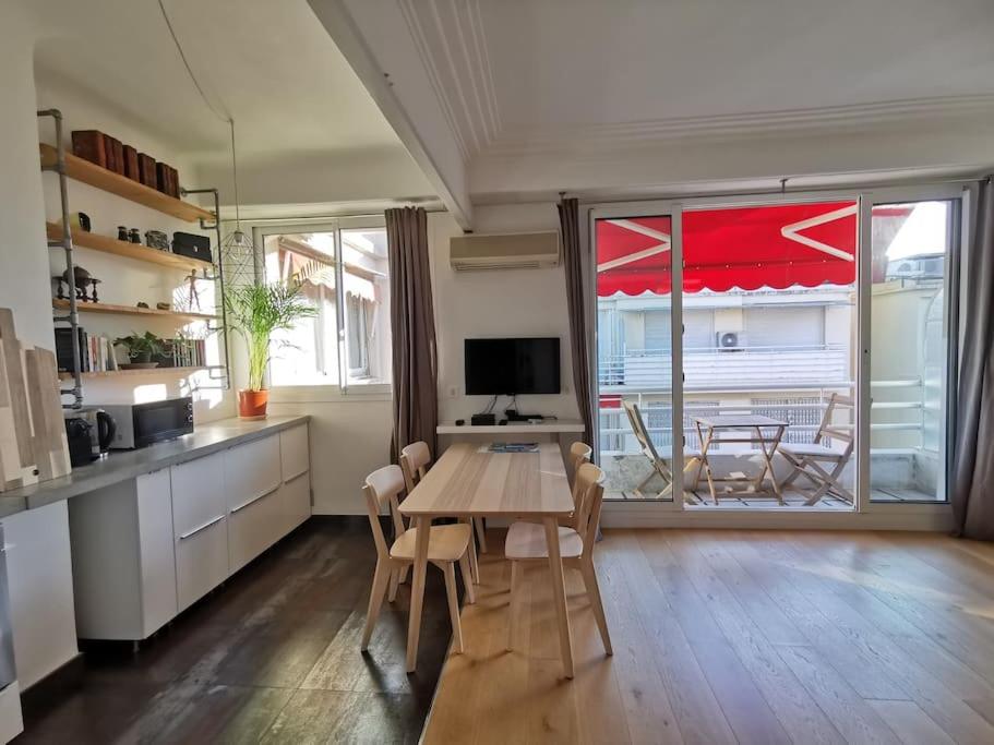 une cuisine avec une table et des chaises ainsi qu'une grande fenêtre dans l'établissement #TheCosyStudio06 Meyerbeer Promenade Negresco, à Nice