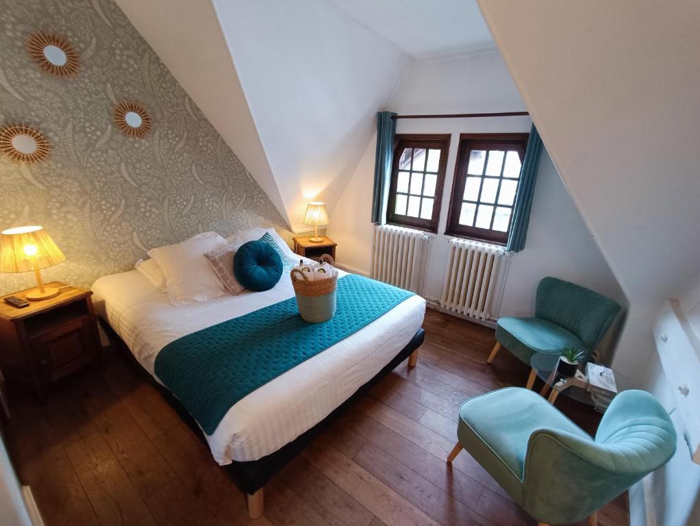 a bedroom with a bed and a blue chair at Hotel La Résidence Manoir De La Salamandre in Étretat
