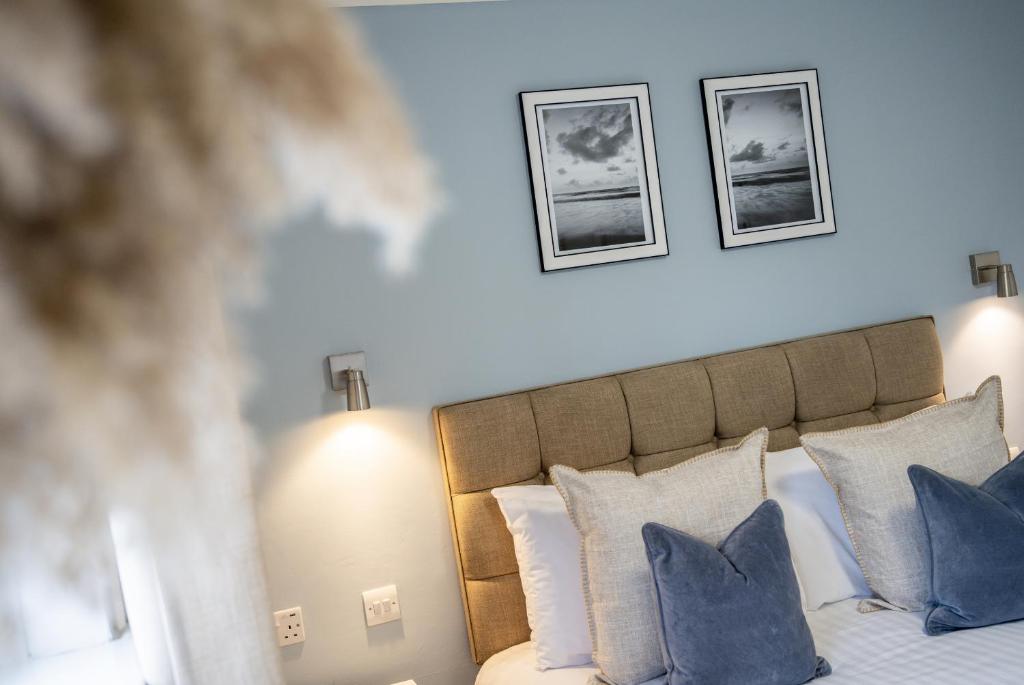 a bedroom with a bed with blue and white pillows at Inn For All Seasons in Redruth