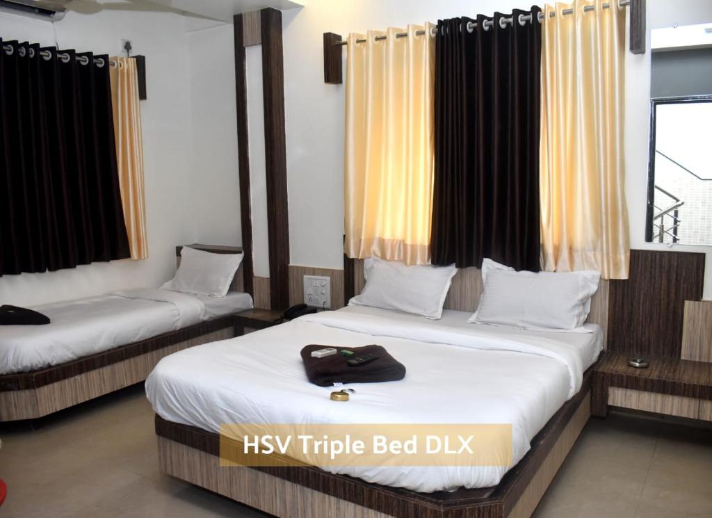 Postel nebo postele na pokoji v ubytování HOTEL SAI VISHVA KARMA