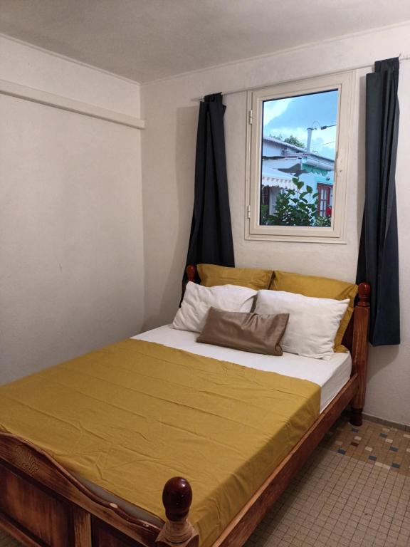 een bed in een kamer met een raam bij VILLA HELENA in Bouillante