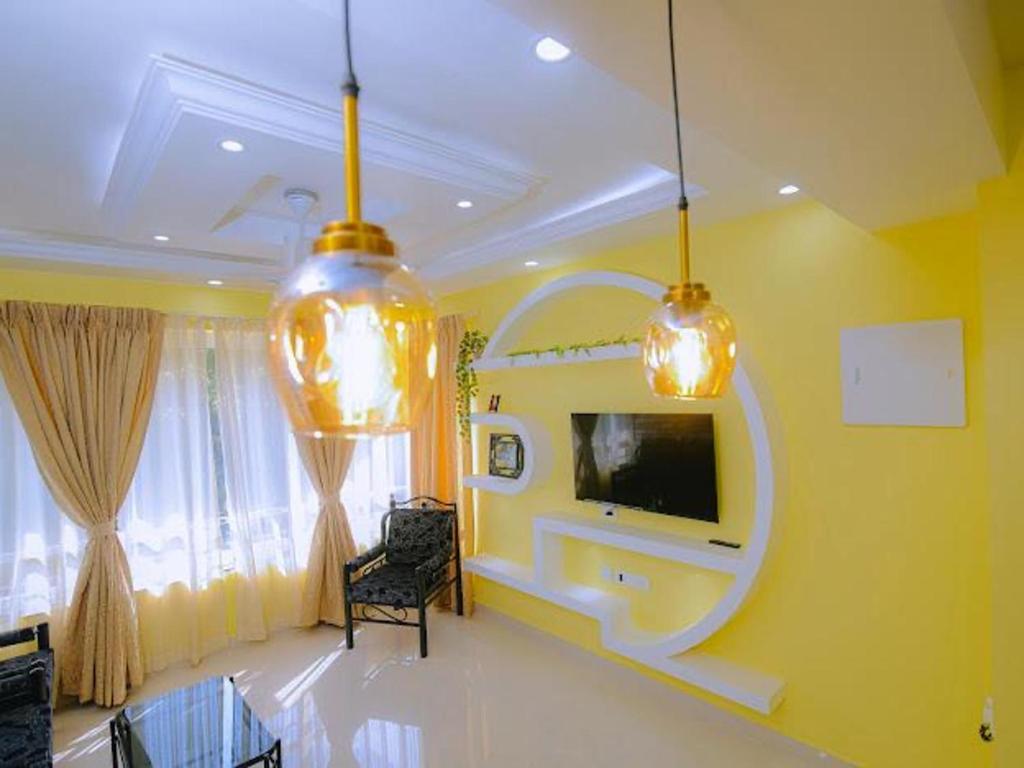 a living room with a tv on a yellow wall at Beachside Bliss Apartment in Colva Salcette- Goa in Colva