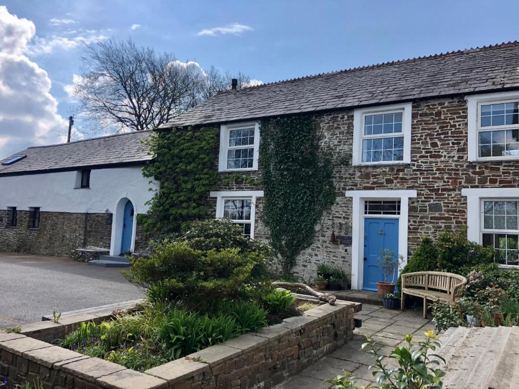 una casa de ladrillo con una puerta azul en Lake Villa Holiday Cottages, en Holsworthy