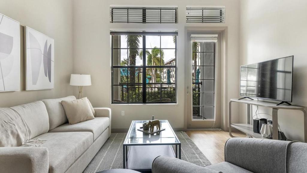 un soggiorno con divano e TV di Landing Modern Apartment with Amazing Amenities (ID1019X387) a Orlando
