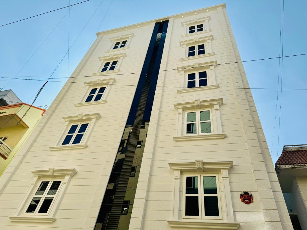 バンガロールにあるOlive Serviced Apartments BTM Layoutのたくさんの窓がある背の高い白い建物