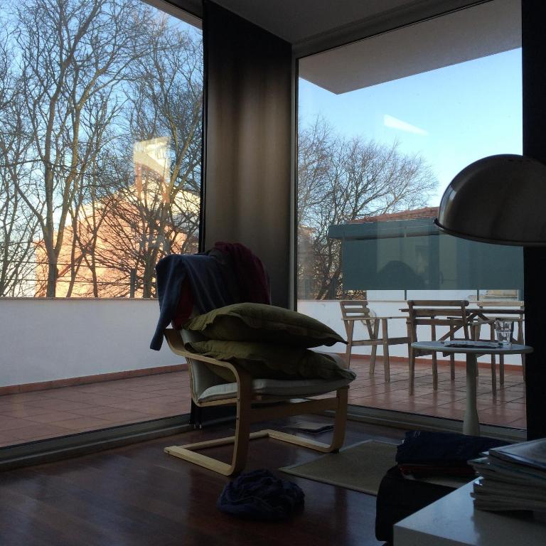 a living room with a chair and a large window at Belong Staying and Feeling - Casa da Sé in Lisbon