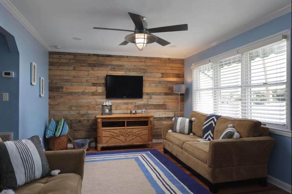 a living room with a couch and a flat screen tv at Island Time- beautifully renovated bay view home in Seaside Heights