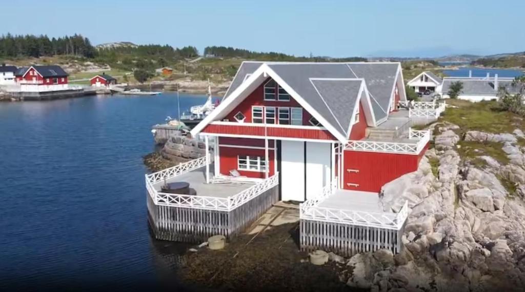 ein rotes und weißes Haus auf einem Wasserkörper in der Unterkunft Atlantic Road Luxury Housing in Averoy