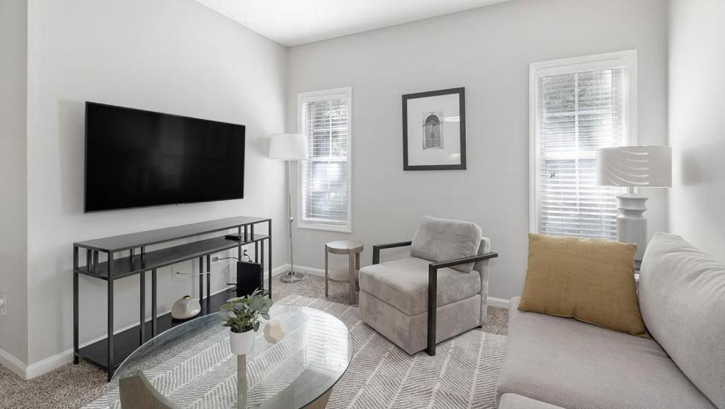 - un salon avec une télévision, un canapé et une chaise dans l'établissement Landing Modern Apartment with Amazing Amenities (ID3077X80), à Atlanta