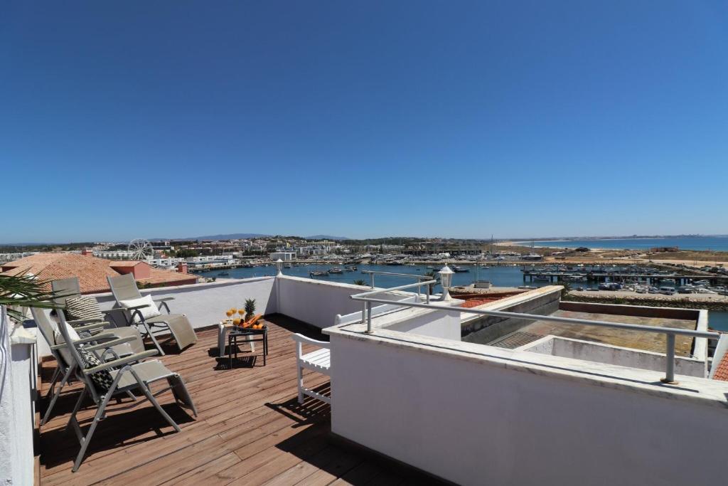 a roof deck with chairs and a view of the water at Apartamento Vista Marina in Lagos