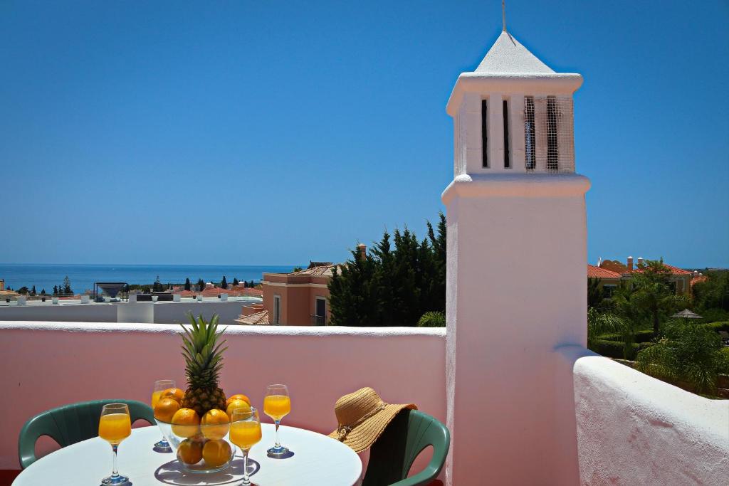 een tafel met wijnglazen op een balkon met een vuurtoren bij Casa Barbara in Armação de Pêra