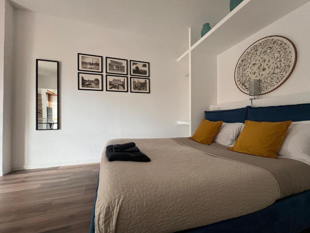 een slaapkamer met een groot bed met gele en blauwe kussens bij Suite Monolocale Roma Eur in Rome