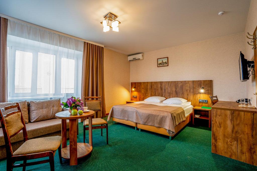 a hotel room with a bed and a couch at Отель Ямской in Voronezh