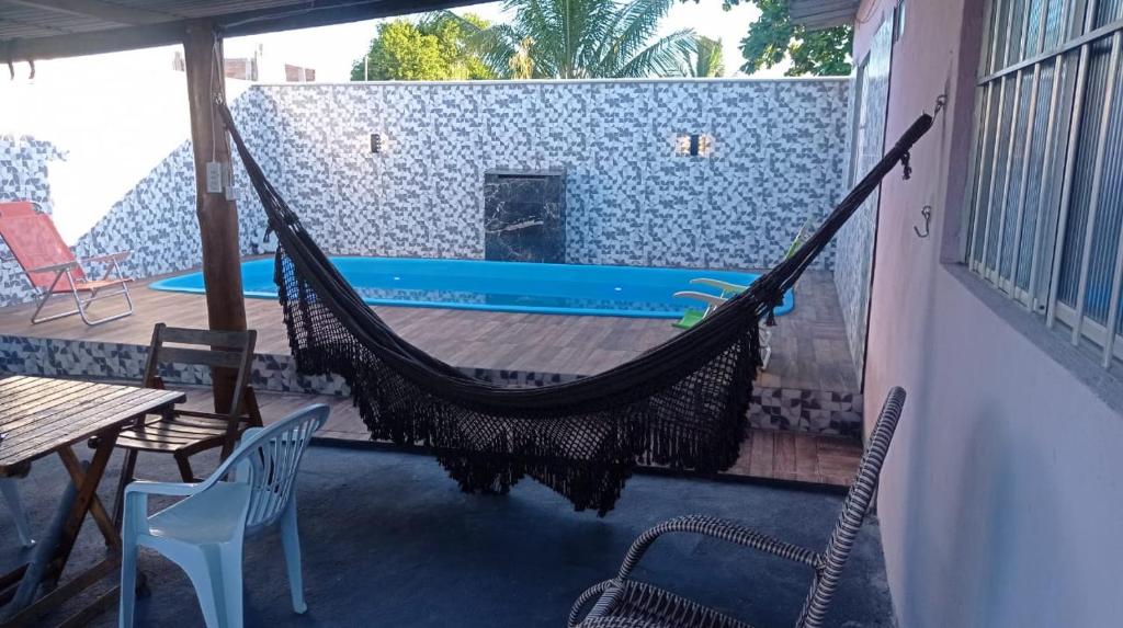 eine Hängematte auf einer Terrasse mit Pool in der Unterkunft Casa Porto in Porto Seguro